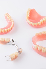 Birds-eye-view of full and partial dentures arranged together on a white surface