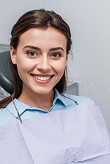 Woman sitting in dental chair and smiling