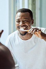 Man brushing his teeth in the mirror