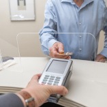 A man using a credit card to pay for dental implants