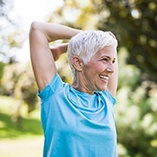 Woman smiling while stretching outside