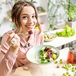 Woman smiling while eating lunch at home